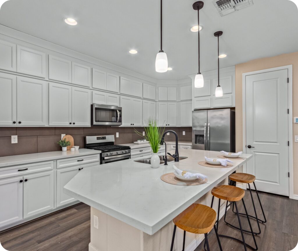 Bright kitchen with white cabinets and island seating – Capstone Realty listing