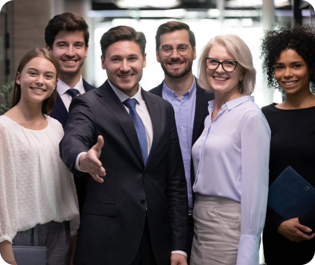 Diverse business team smiling and welcoming with handshake gesture in modern office