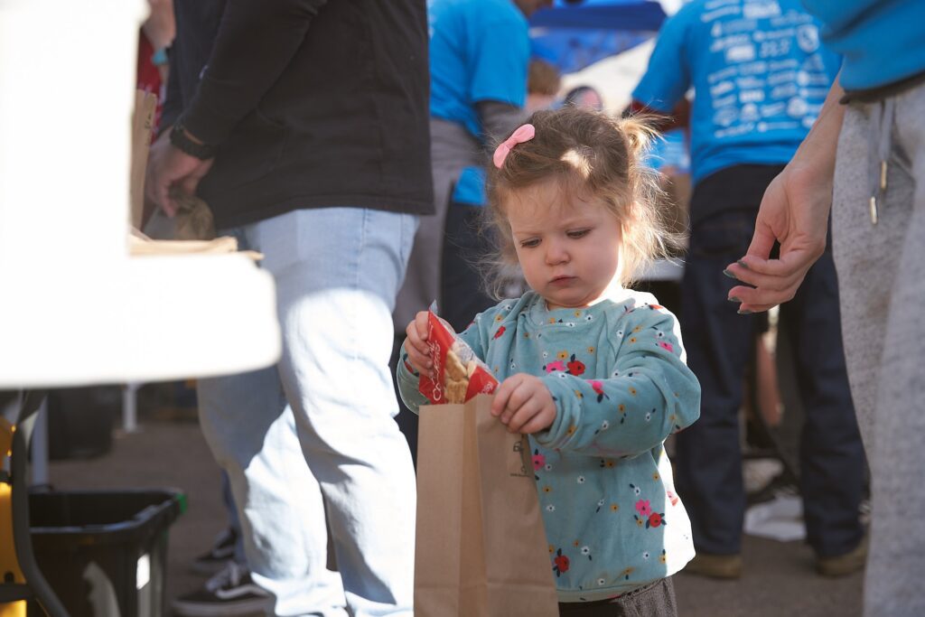 Young child volunteering at Capstone Contributes community event